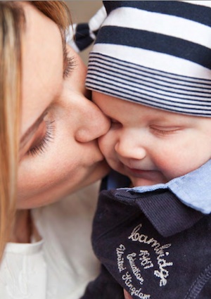 baby crawling kissed by mum